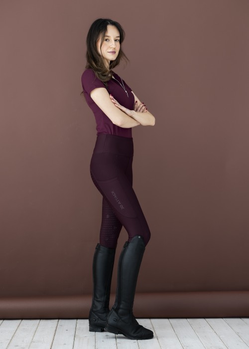 Bordowe legginsy jeździeckie Sportiva z wysokim stanem i pełnym lejem silikonowym. Skład: 78% poliester, 22% elastan. Elastyczne, z kieszenią na telefon – idealne połączenie wygody i stylu w siodle.