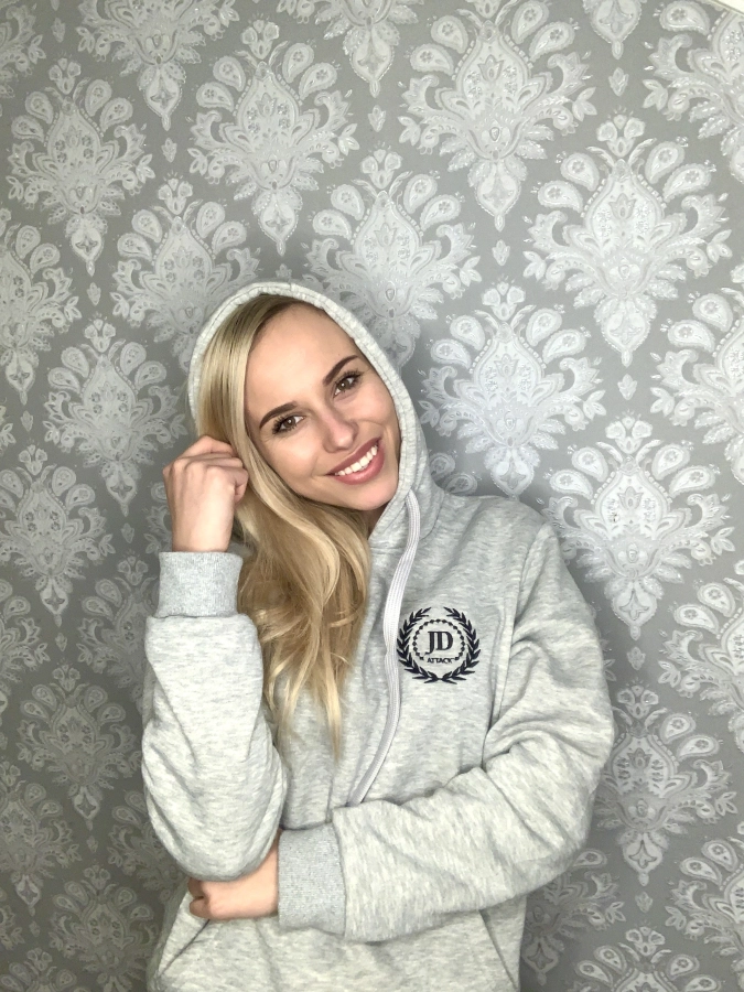 Uśmiechnięta modelka w szarej bluzie z kapturem Basic z haftowanym logo